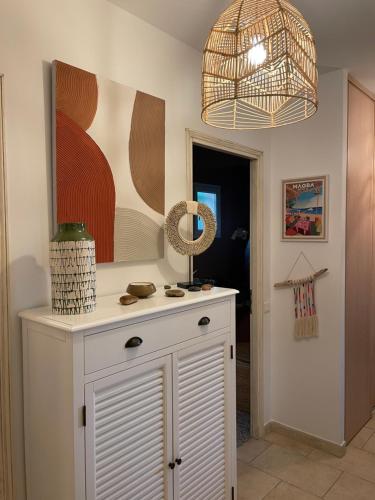 une chambre avec une armoire blanche et un tableau dans l'établissement Maison Porto vecchio proche belles plages, à Porto-Vecchio
