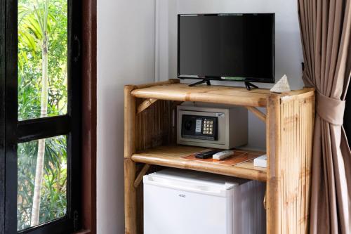 a television and a microwave on a shelf in a room at Tropical Heavens Garden Samui in Lipa Noi