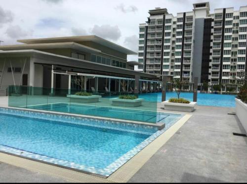 a swimming pool in front of a building at Sandakan Ijm pool view condo in Sandakan