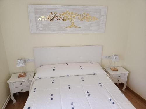 a bedroom with a white bed with two night stands at PISO XUNQUEIRA in Viveiro