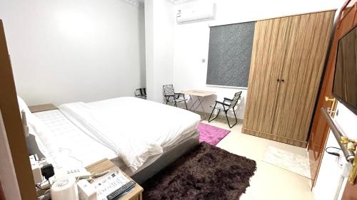 a bedroom with a bed and a table and chairs at القبة الذهبية للشقق المخدومة in Riyadh