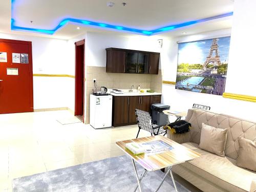 a living room with a couch and a kitchen at القبة الذهبية للشقق المخدومة in Riyadh