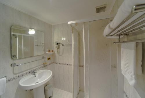 a white bathroom with a sink and a shower at Hotel Columbus sul Lago in Bolsena
