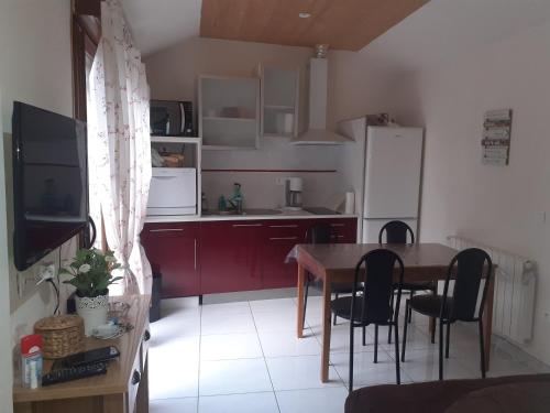 une petite cuisine avec une table et un réfrigérateur dans l'établissement Paquito, mini maison 1 chambre avec terrasse et parking, à Ax-les-Thermes
