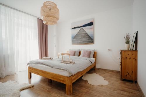 - une chambre avec un grand lit aux murs blancs dans l'établissement Resort Stories Išskirtiniai 7 vietų apartamentai Birštone, à Birštonas