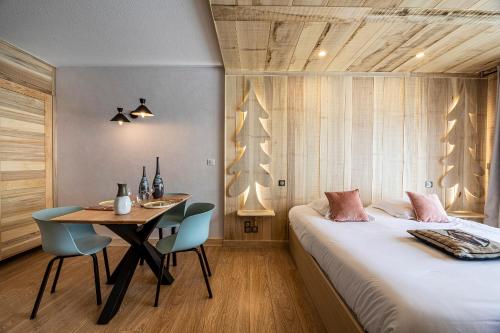 a bedroom with a bed and a table with chairs at Les Maisons de Montagne - Chez Marie in Pailherols