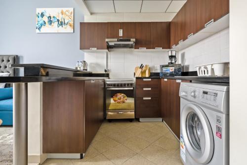 a kitchen with a dishwasher and a washer at Modern Studio Sports City Pool & City Views in Dubai