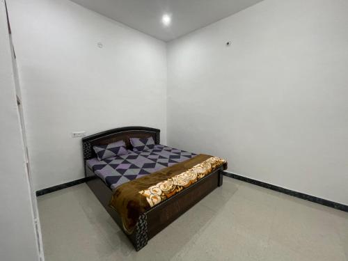 a small bedroom with a bed in the corner at Rukmani Villas Group of Rukmani home stay in Mathura