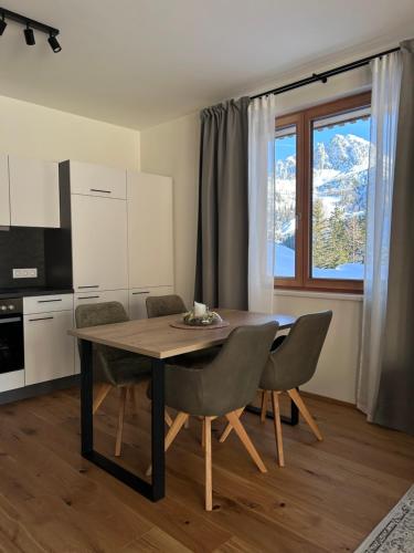 uma cozinha com mesa e cadeiras num quarto em Almappartement Nassfeld- Sonnenalpe em Sonnenalpe Nassfeld