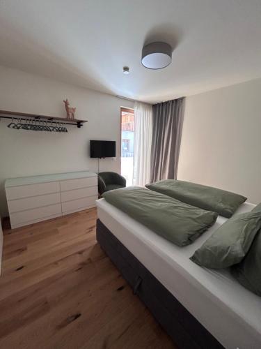 Un dormitorio con una cama grande y una ventana en Almappartement Nassfeld- Sonnenalpe, en Sonnenalpe Nassfeld