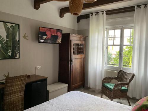 1 dormitorio con cama, escritorio y ventana en La Marjolaine, en Juan-les-Pins