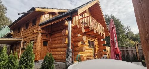 uma cabina de madeira com um deque ao lado em Kanadský zrub em Prievidza