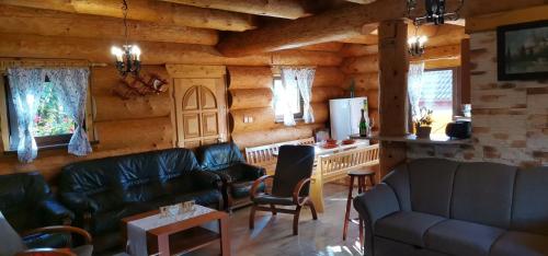 a living room with leather furniture in a log cabin at Kanadský zrub in Prievidza