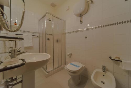 a white bathroom with a sink and a toilet at Hotel Columbus sul Lago in Bolsena