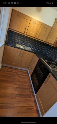 a kitchen with wooden cabinets and a sink at Private 1bedroom home in North Tyneside