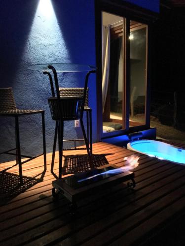 a chair sitting on a deck with a light at Estalagem Meraki - Cunha SP in Cunha