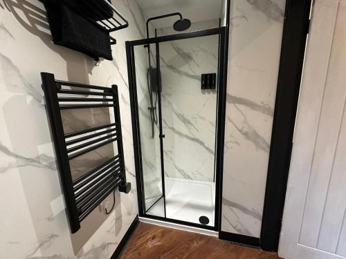 a shower with a glass door in a bathroom at The Cottage Hideout in Upholland