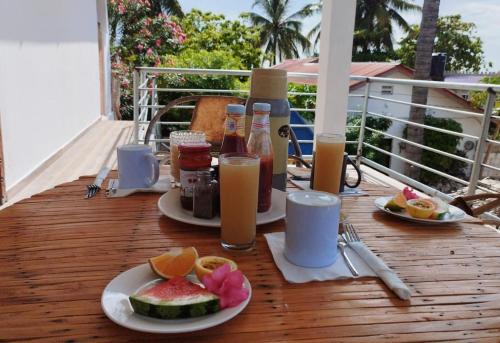 una mesa con platos de comida y bebida en el balcón en Pamoja Beach Stays Hotel in Jambiani, en Jambiani