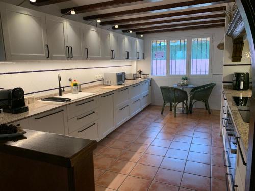 a large kitchen with white cabinets and a table at 10 Bedroom 5 Star Luxury Villa & Heated Pool for 5 to 28 Guests near Alicante in Mutxamel