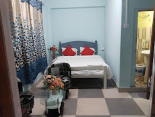 a bedroom with a bed with red pillows at Winnie's Lodge , Shillong in Shillong