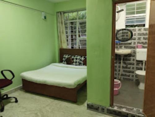 a small bedroom with a bed and a mirror at Winnie's Lodge , Shillong in Shillong