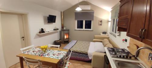 Kleines Zimmer mit einem Bett und einer Küche mit einem Tisch. in der Unterkunft La Tana del Berü in Varraze