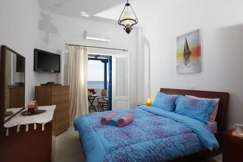 Schlafzimmer mit einem blauen Bett und Meerblick in der Unterkunft Alexandros House in Monolithos