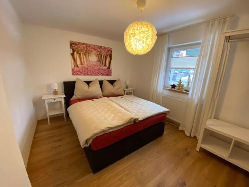 una camera da letto con un letto e un dipinto sul muro di Herzzeit Apartments a Flachau