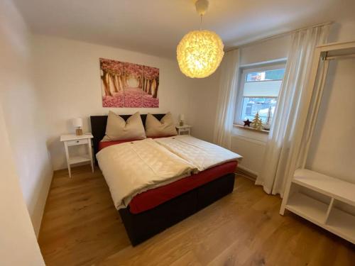 a bedroom with a bed with a painting on the wall at Herzzeit Apartments in Flachau