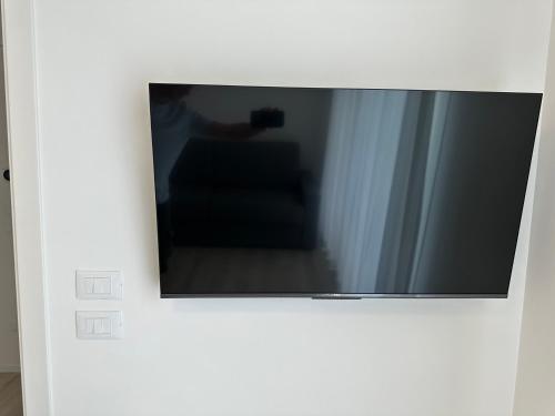 a flat screen tv hanging on a wall at Haus Margarete - Attico Infinity Vista Mare con Jacuzzi - Agenzia Cocal in Caorle
