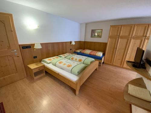a bedroom with two beds and a television in it at Appartamenti la Fontana in San Martino in Badia