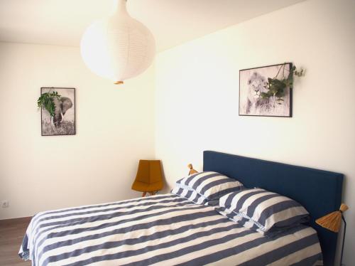 a bedroom with a blue and white striped bed at Villa Au Bain Marie in São Martinho do Porto
