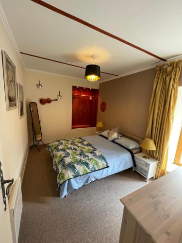 um quarto com uma cama, uma mesa e uma janela em Willow Farm Gite em Saint-Martin-de-Chaulieu