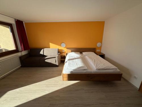 a bedroom with a bed and a couch at Hotel LukasMayr in Bruck an der Großglocknerstraße