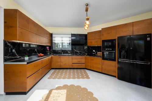 a large kitchen with wooden cabinets and black appliances at Hideaway Villa in Triánta