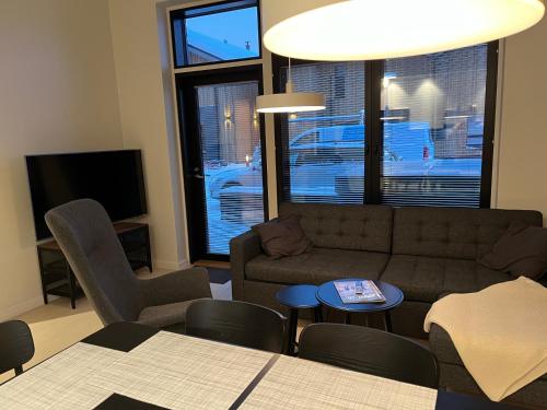 a living room with a couch and chairs and a tv at Levi Cranberry C1, ski-in ski-out 2 bedroom apartment in Levi center in Levi