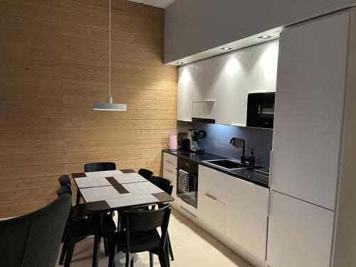 a kitchen with a table and chairs and a kitchen with white cabinets at Levi Cranberry C1, ski-in ski-out 2 bedroom apartment in Levi center in Levi