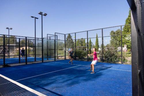 2 personnes jouant au tennis sur un court dans l'établissement Glamping Limburg - nabij Nationaal Park Hoge Kempen, à Kinrooi
