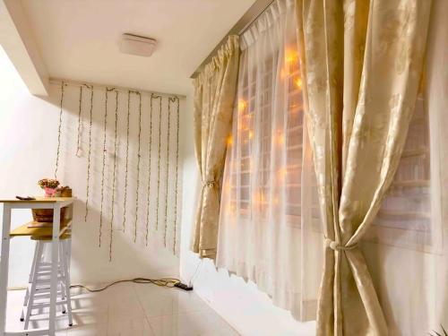 a room with a window with curtains and a stool at Free & Easy Leisure Homestay in Batu Caves