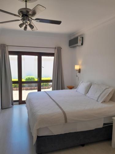 - une chambre avec un lit et un ventilateur de plafond dans l'établissement Almost Heaven, à Durban