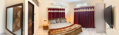 a bedroom with a bed and red curtains at Bethel House Holiday Stay-inn in Alibaug