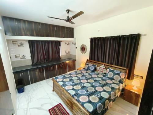 a bedroom with a bed and a ceiling fan at Bethel House Holiday Stay-inn in Alibaug
