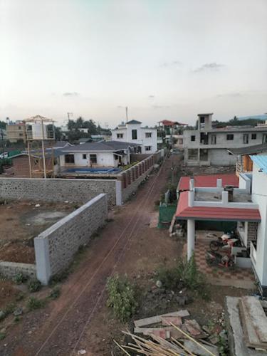 a view of a city with buildings and a dirt road at Bethel House Holiday Stay-inn in Alibaug