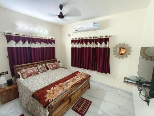 a bedroom with a bed and red curtains at Bethel House Holiday Stay-inn in Alibaug
