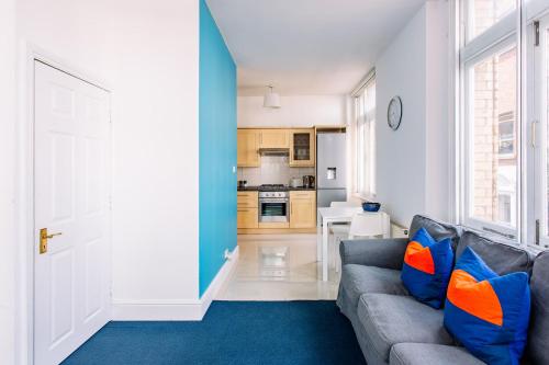 a living room with a gray couch and a blue rug at Apartments are located in the Heart of Shoreditch in London