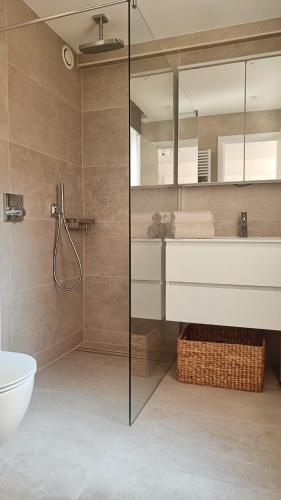 een badkamer met een douche, een toilet en een wastafel bij Suite Maritim - Zijdelings zeezicht op 50m van strand en zee in Knokke-Heist