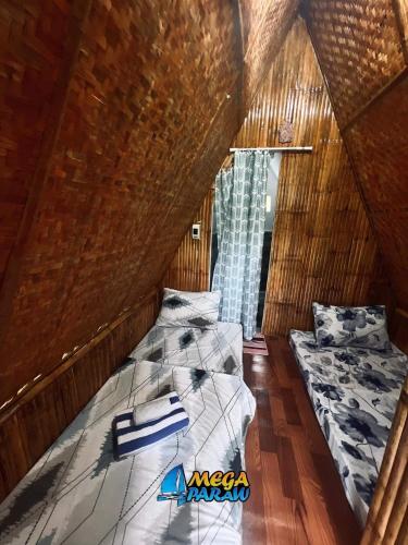 um quarto com 2 camas numa casa de madeira em Enchanting Paraw Resort - Fan Room em Boracay