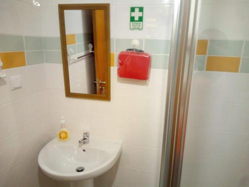 een badkamer met een wastafel en een spiegel bij Costa Lodge Madeira, pick up - drop off, car and motorcycle rentals in Santa Cruz