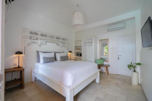 a white bedroom with a large white bed in it at The Room Padang-Padang in Uluwatu
