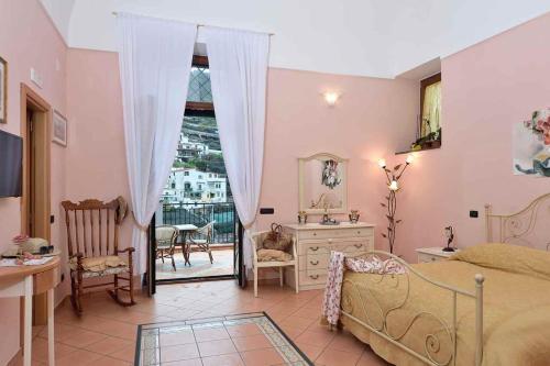 1 dormitorio con cama, escritorio y ventana en Villa Anna, en Minori